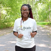 Black women with braids and glasses standing on a nature trail