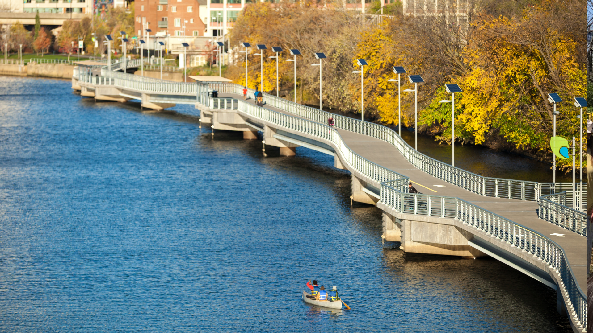 Photo of the trail and water, a man kayaks near the bottom of the image.