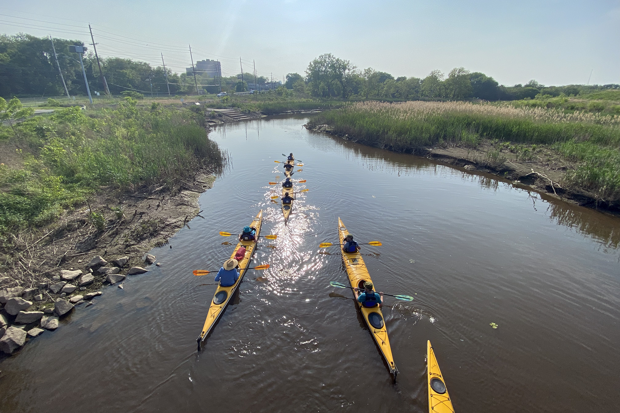 four yellow kayaks in the river